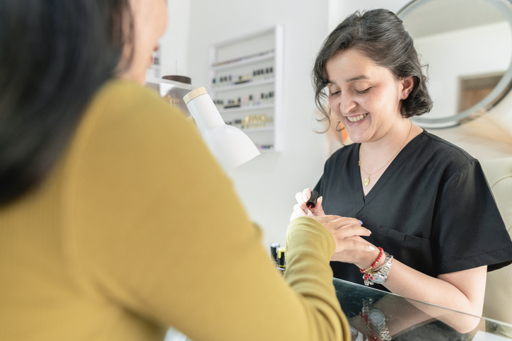 Manicurist applying polish for a client