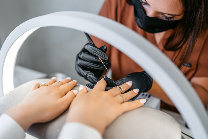 Nail technician painting French tips