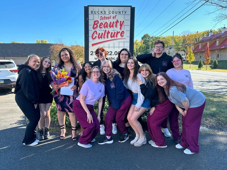 BCSBC students in front of the school sign